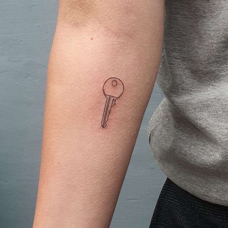 simple cute key tattoo on the arm
