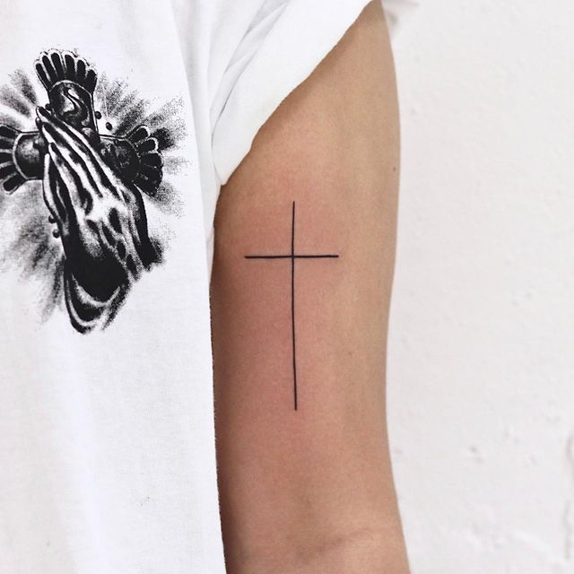 most minimalist cross tattoo on arm